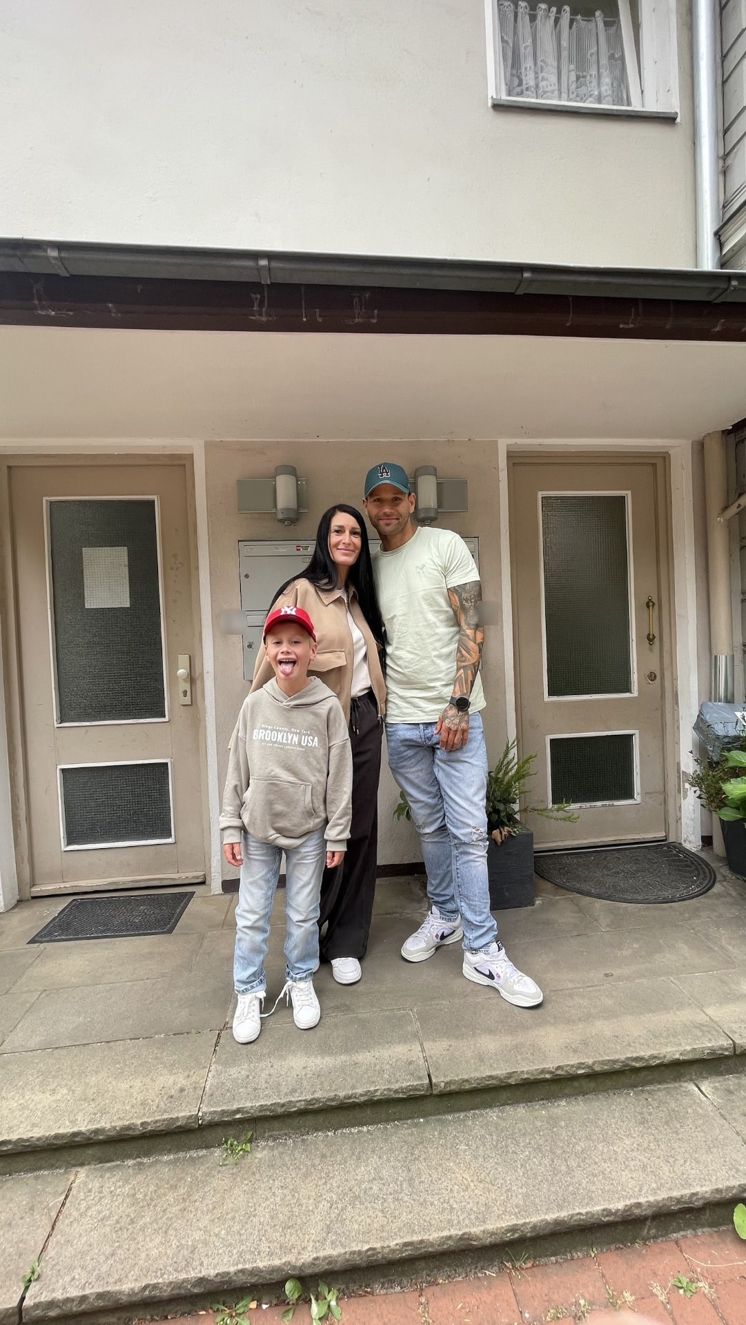 Manuela, Patrick und ihr Sohn vor der Haustür ihrer ersten vermieteten Wohnung