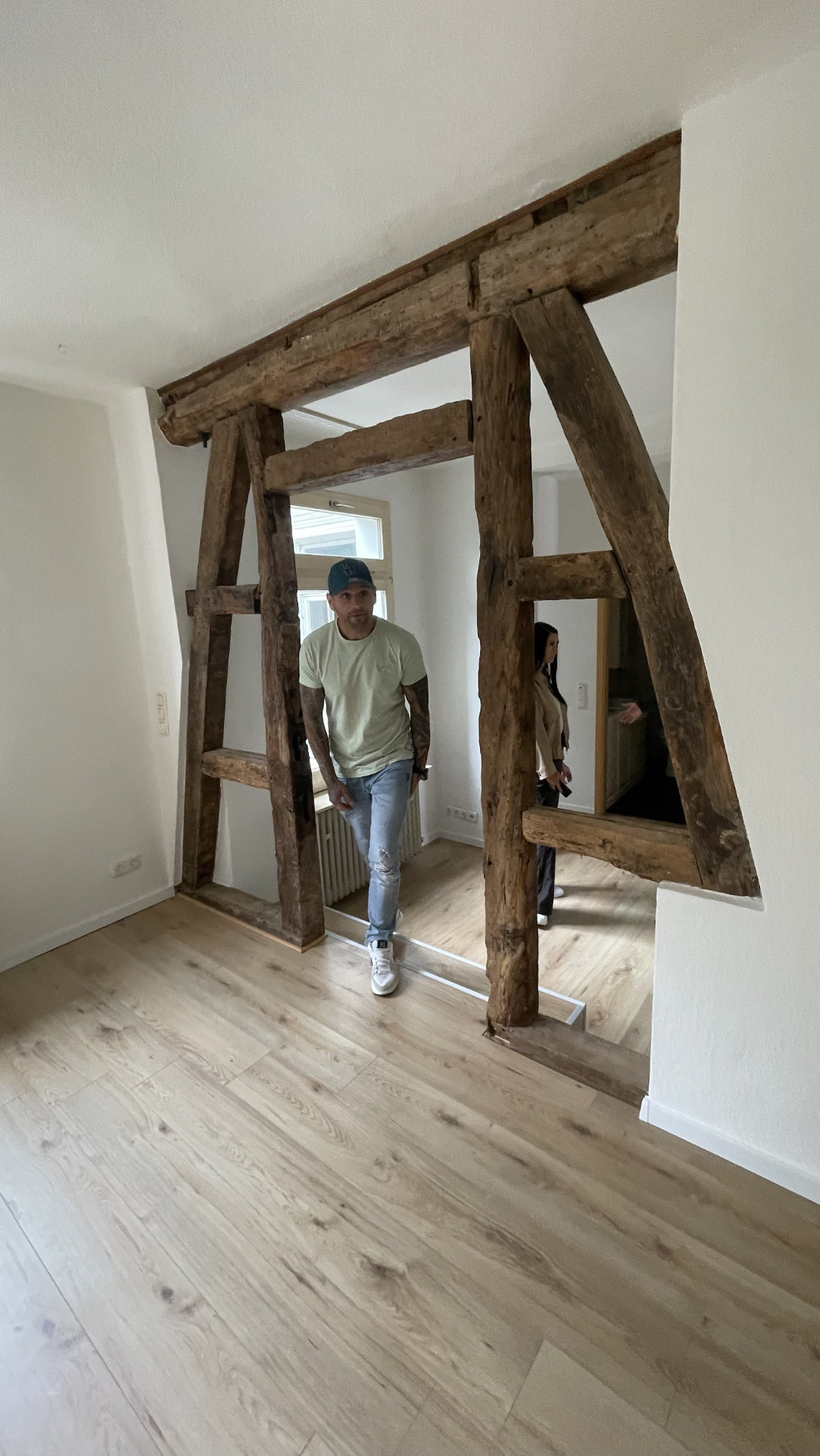 Patrick steigt durch das alte Holz-Fachwerk in der modernisierten Wohnung